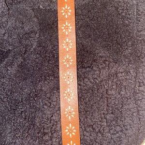 Brown leather belt with embroidered daisy chain design.